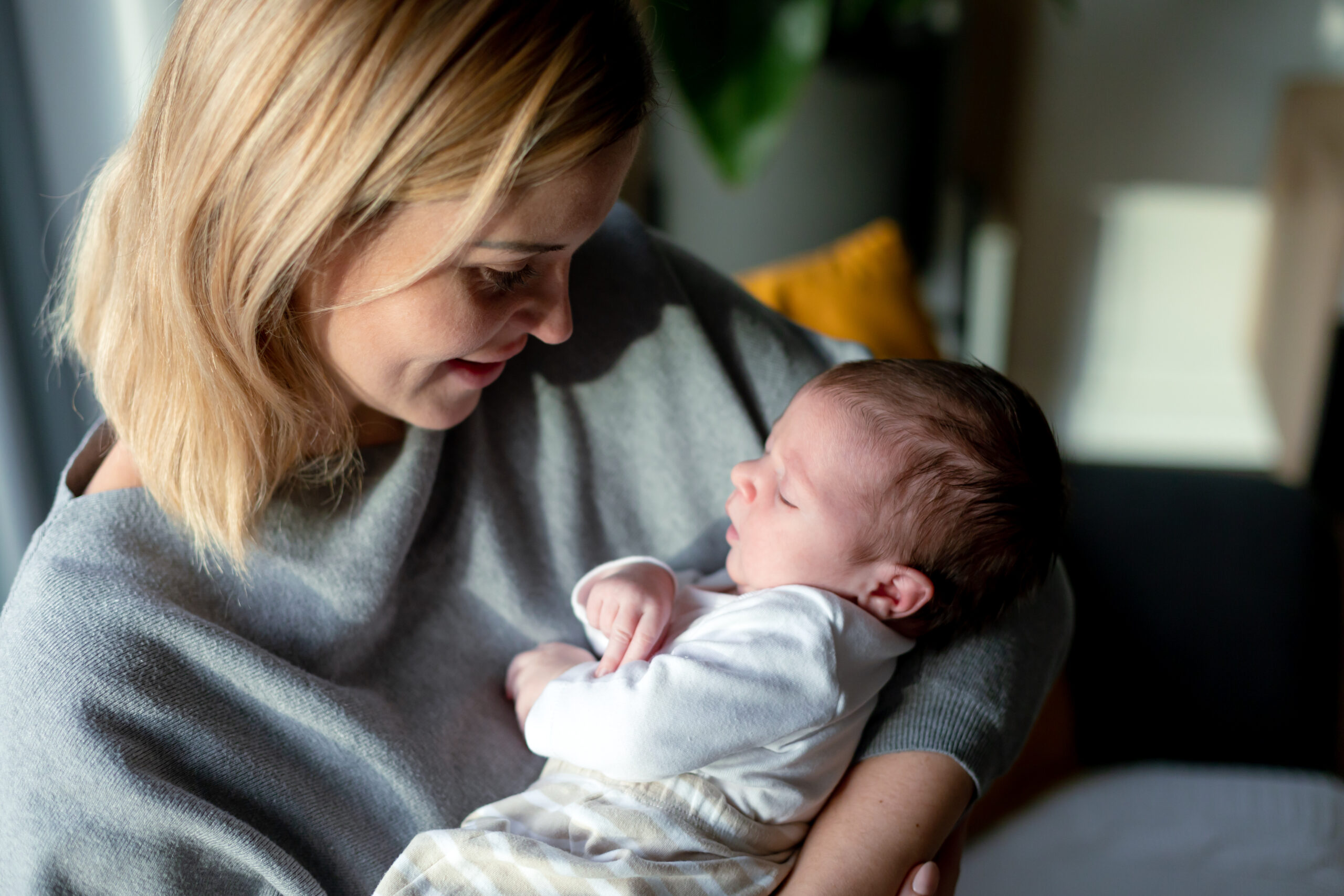 Loving mother hugs her little baby at home